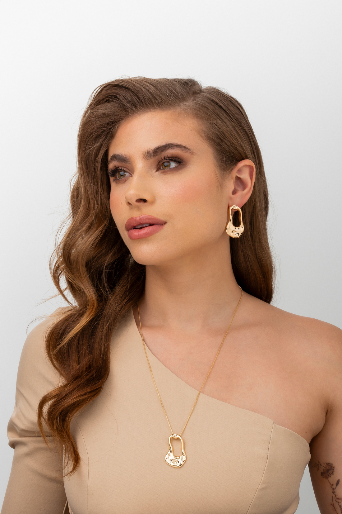 Necklace with twisted oval silhouette pedant with elevations